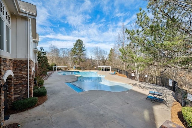 community pool with fence and a patio