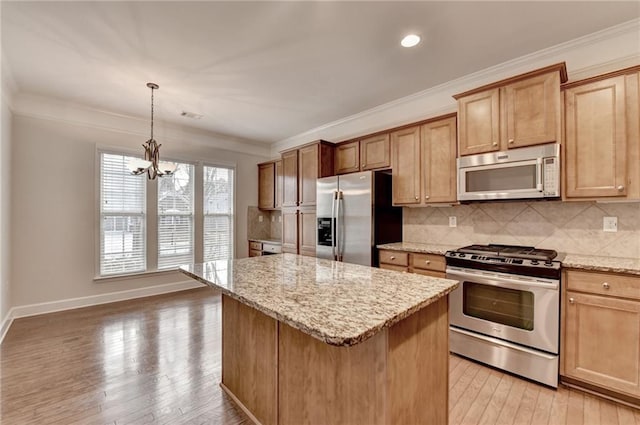 kitchen featuring backsplash, stainless steel appliances, crown molding, and light wood-style floors