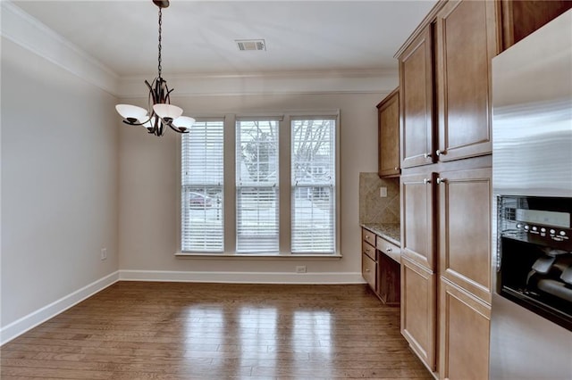 kitchen featuring visible vents, a chandelier, stainless steel fridge, ornamental molding, and wood finished floors