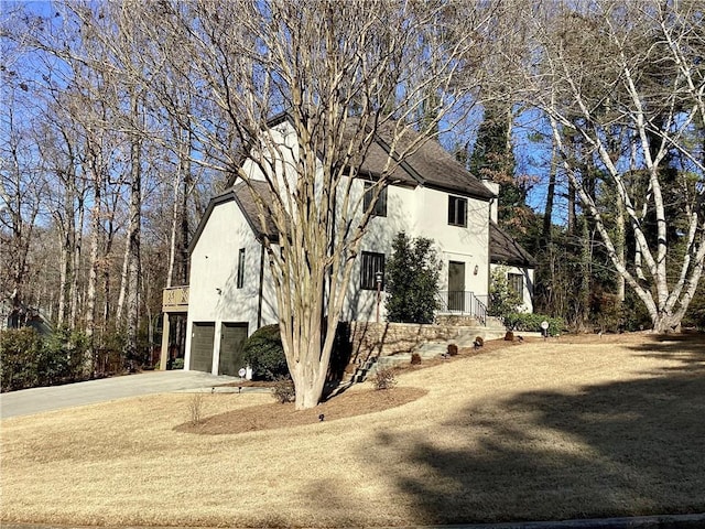 view of property exterior with a garage, driveway, and stucco siding