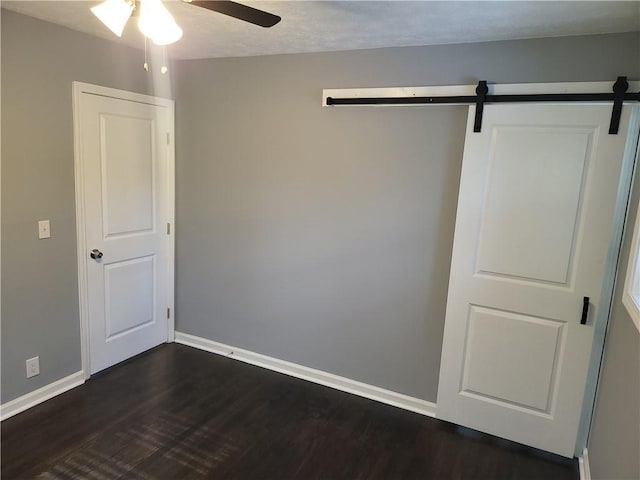 4664 Ryan Rd, Conley, GA 30288 - unfurnished room with dark wood-style flooring, a ceiling fan, baseboards, and a barn door