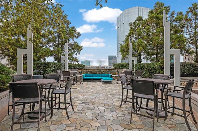 view of patio with an outdoor hangout area, outdoor dining area, and a city view