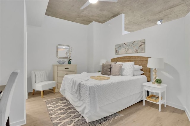 bedroom featuring light wood-style floors, baseboards, and a ceiling fan