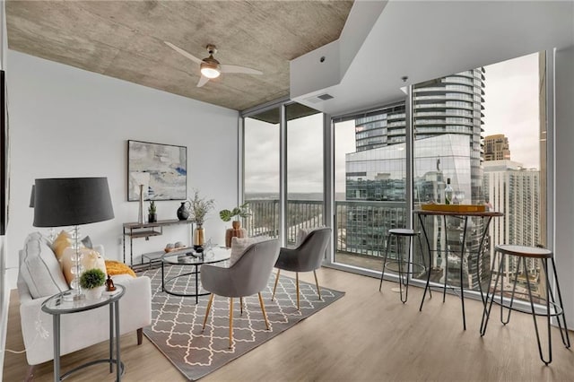 interior space featuring visible vents, wood finished floors, a ceiling fan, and floor to ceiling windows