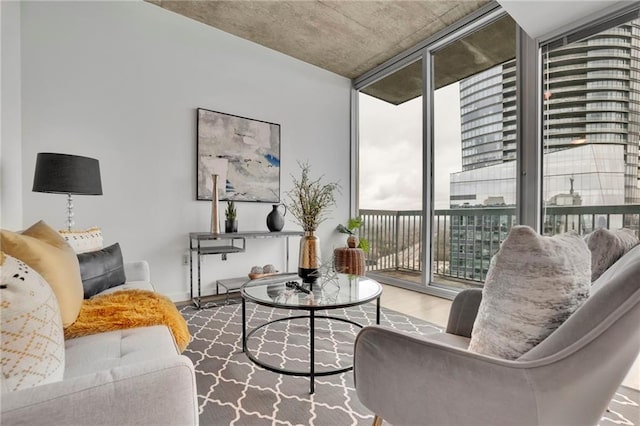 living room with baseboards, wood finished floors, and floor to ceiling windows