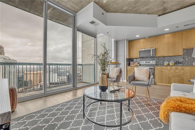 living area with visible vents and wood finished floors