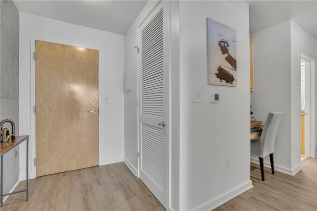 corridor featuring baseboards and light wood-style floors