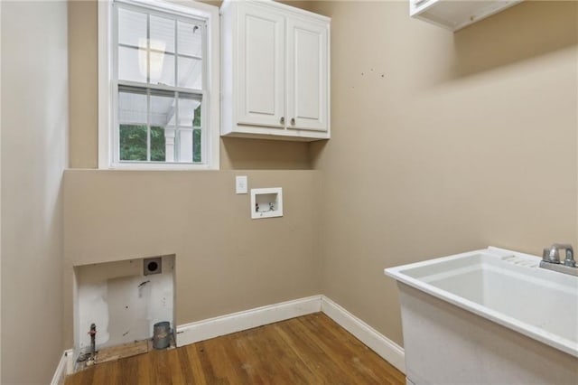 washroom with gas dryer hookup, sink, cabinets, hardwood / wood-style flooring, and washer hookup