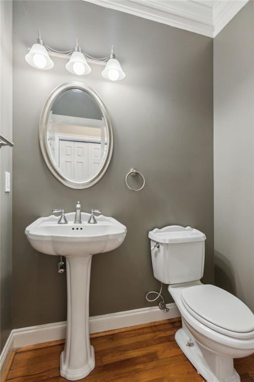 bathroom with sink, wood-type flooring, ornamental molding, and toilet