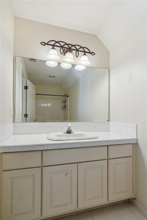 bathroom with walk in shower, lofted ceiling, and vanity