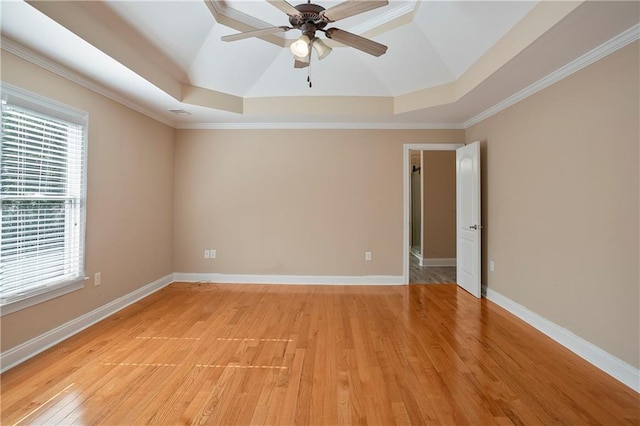 unfurnished room with ornamental molding, a tray ceiling, light wood-type flooring, and ceiling fan
