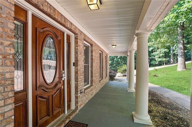 doorway to property featuring a yard and covered porch