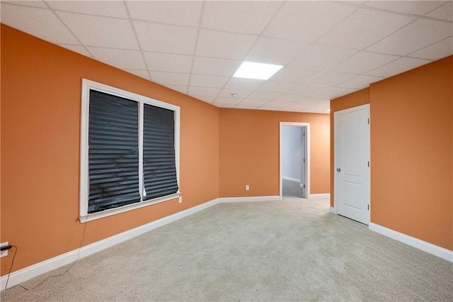 unfurnished room featuring a drop ceiling and carpet