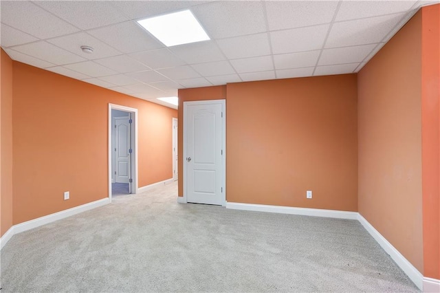 spare room with a drop ceiling and carpet flooring