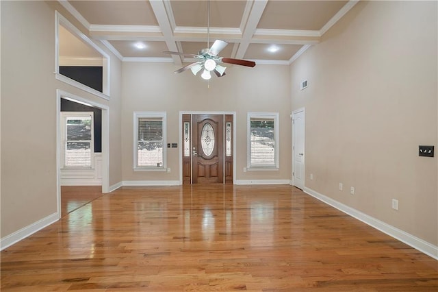 foyer entrance with a high ceiling, light wood-type flooring, ceiling fan, and coffered ceiling