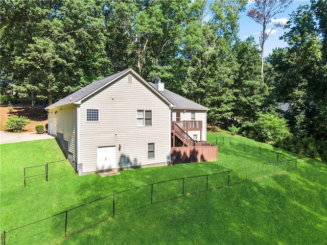 rear view of house with a wooden deck and a lawn