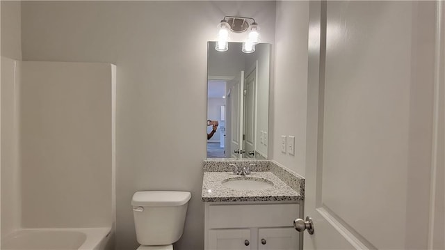 bathroom featuring washtub / shower combination, vanity, and toilet