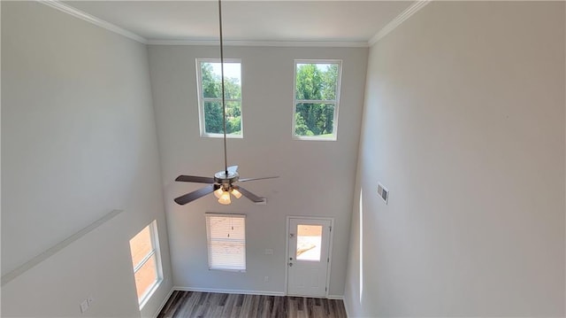 foyer featuring visible vents, crown molding, baseboards, and wood finished floors