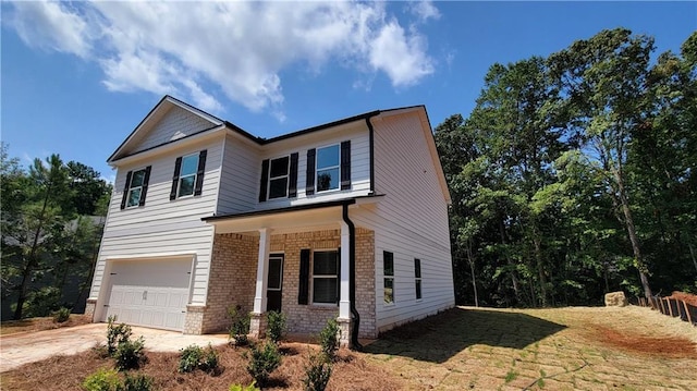 view of front of home featuring a garage, a front yard, concrete driveway, and brick siding