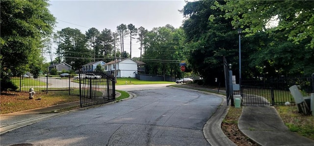 5719 Singlebriar Ct, Norcross, GA 30093 - view of asphalt road with sidewalks, a gate, street lighting, and curbs