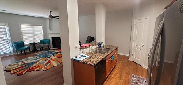 5719 Singlebriar Ct, Norcross, GA 30093 - kitchen with black dishwasher, a sink, freestanding refrigerator, ceiling fan, and light wood-type flooring