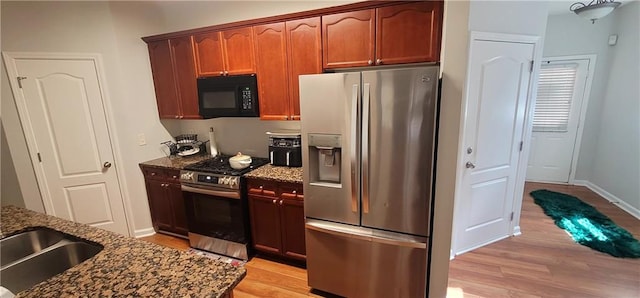 5719 Singlebriar Ct, Norcross, GA 30093 - kitchen with stainless steel appliances, dark stone countertops, light wood-style flooring, and baseboards