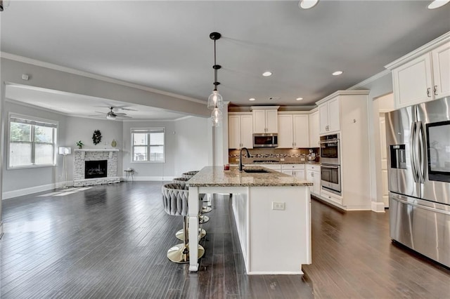 7470 Oldbury Pl, Cumming, GA 30040 - kitchen with stainless steel appliances, a sink, healthy amount of natural light, light stone countertops, and recessed lighting