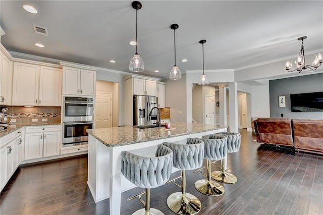 7470 Oldbury Pl, Cumming, GA 30040 - kitchen with stainless steel appliances, backsplash, ornamental molding, light stone countertops, and open floor plan