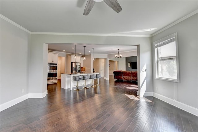 7470 Oldbury Pl, Cumming, GA 30040 - living room featuring baseboards, ornamental molding, dark wood finished floors, a ceiling fan, and a chandelier