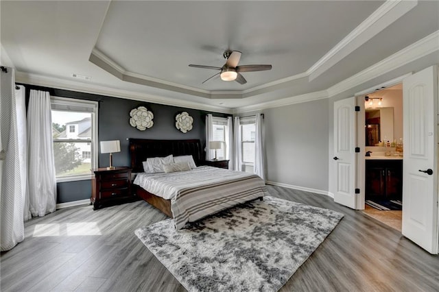 7470 Oldbury Pl, Cumming, GA 30040 - bedroom with a raised ceiling, multiple windows, crown molding, wood finished floors, and baseboards