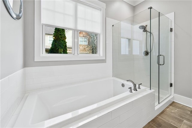 bathroom with independent shower and bath and wood-type flooring