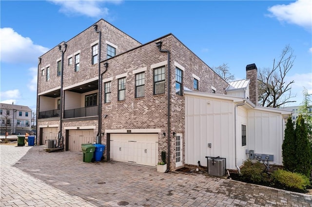 view of side of property with a garage and central air condition unit