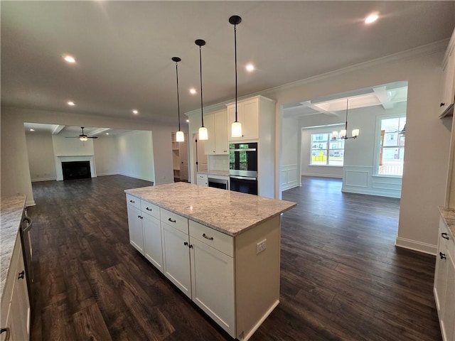 3677 Thornhill Ct, Douglasville, GA 30135 - kitchen featuring open floor plan, stainless steel double oven, a chandelier, crown molding, and white cabinetry
