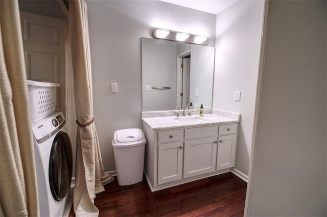 bathroom featuring toilet, wood-type flooring, washer / clothes dryer, and vanity