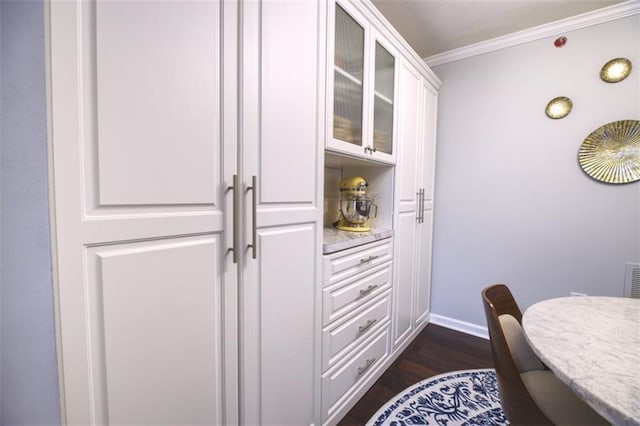 interior space with dark hardwood / wood-style flooring and ornamental molding