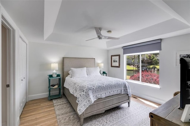 705 Berry Ct, Villa Rica, GA 30180 - bedroom featuring a tray ceiling, light wood-style flooring, baseboards, and ceiling fan