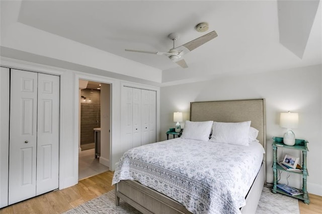 705 Berry Ct, Villa Rica, GA 30180 - bedroom featuring light wood-type flooring, ensuite bathroom, ceiling fan, baseboards, and multiple closets