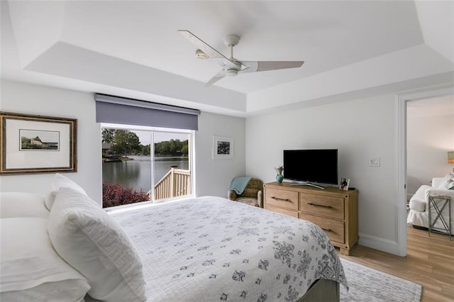 705 Berry Ct, Villa Rica, GA 30180 - bedroom featuring a raised ceiling, access to outside, light wood finished floors, baseboards, and ceiling fan