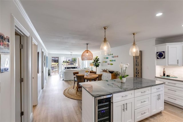 705 Berry Ct, Villa Rica, GA 30180 - kitchen featuring beverage cooler, white cabinetry, open floor plan, decorative backsplash, and a center island