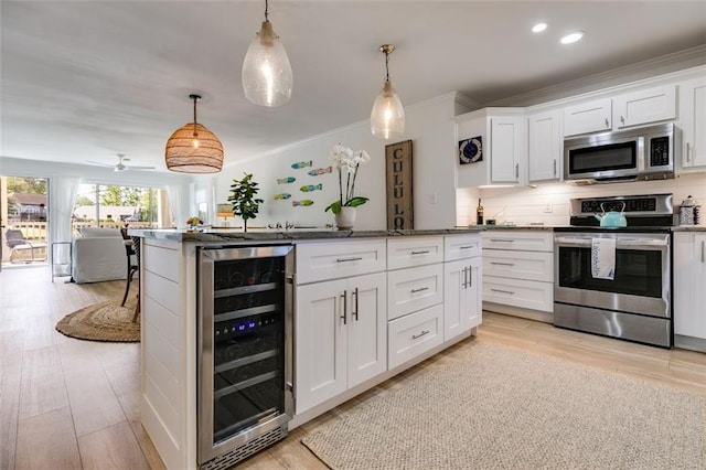 705 Berry Ct, Villa Rica, GA 30180 - kitchen featuring stainless steel appliances, wine cooler, white cabinets, crown molding, and decorative backsplash