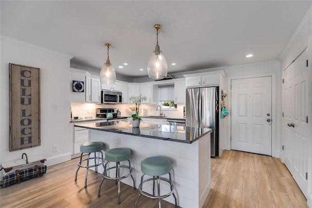 705 Berry Ct, Villa Rica, GA 30180 - kitchen featuring appliances with stainless steel finishes, white cabinets, a breakfast bar, light wood-style flooring, and ornamental molding