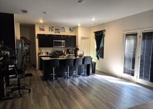 kitchen featuring kitchen peninsula, dark wood-type flooring, a breakfast bar area, and stainless steel appliances