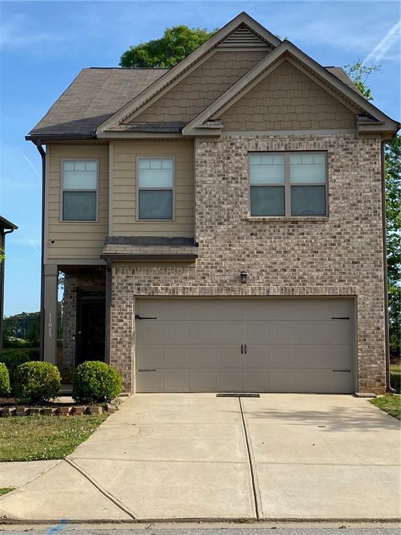 craftsman-style house with a garage, brick siding, and driveway