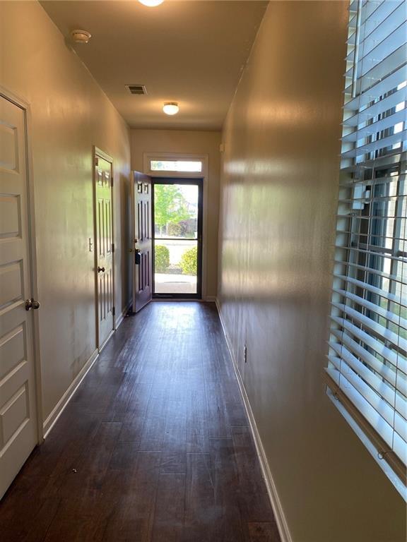 doorway to outside featuring dark wood-style flooring and baseboards