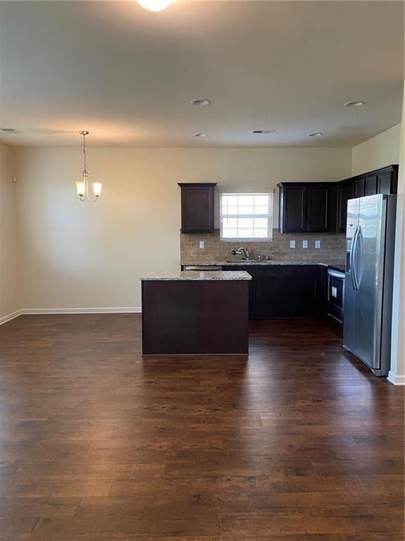 kitchen featuring stainless steel fridge with ice dispenser, a sink, dark wood finished floors, decorative backsplash, and recessed lighting