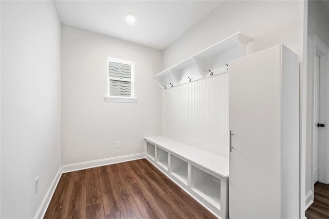 mudroom featuring dark wood-type flooring and baseboards