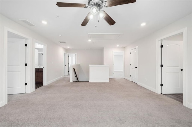 empty room with attic access, light colored carpet, a ceiling fan, baseboards, and recessed lighting