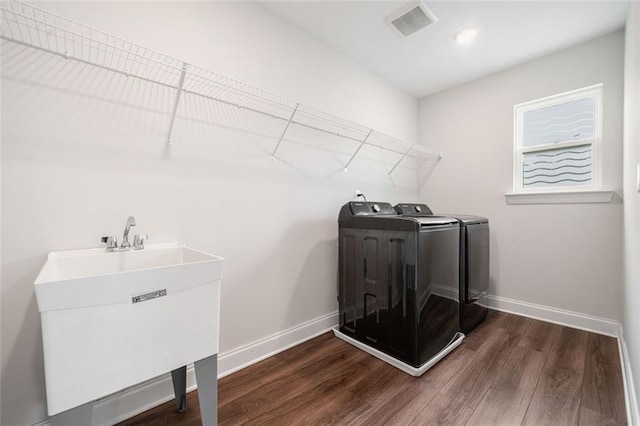 clothes washing area featuring washing machine and clothes dryer, baseboards, dark wood-style floors, and recessed lighting