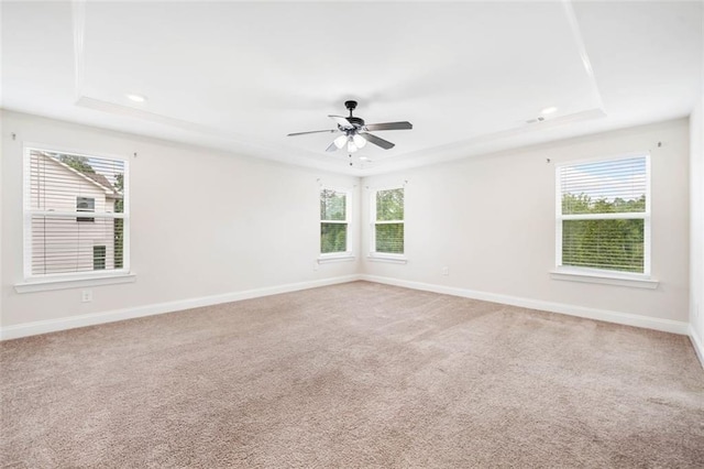 spare room featuring a tray ceiling, plenty of natural light, baseboards, and recessed lighting