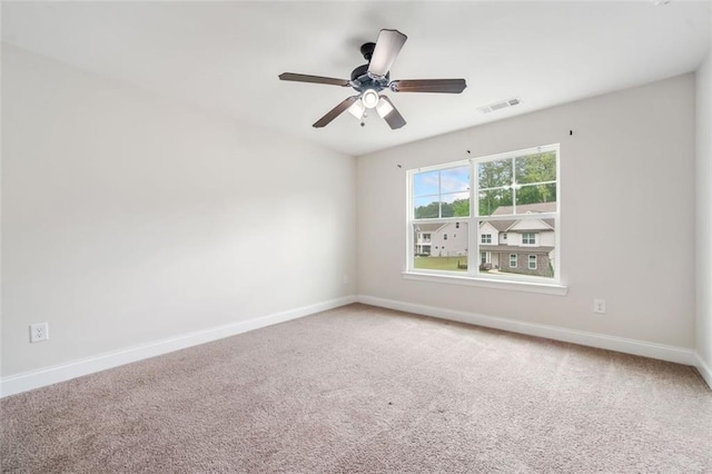 carpeted spare room with baseboards and ceiling fan